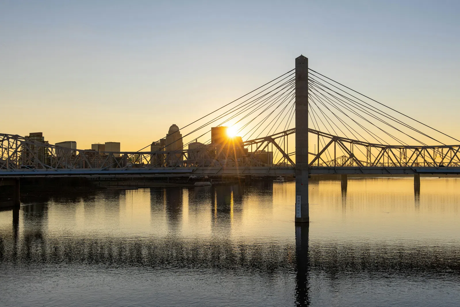 a bridge over water with a city in the background
