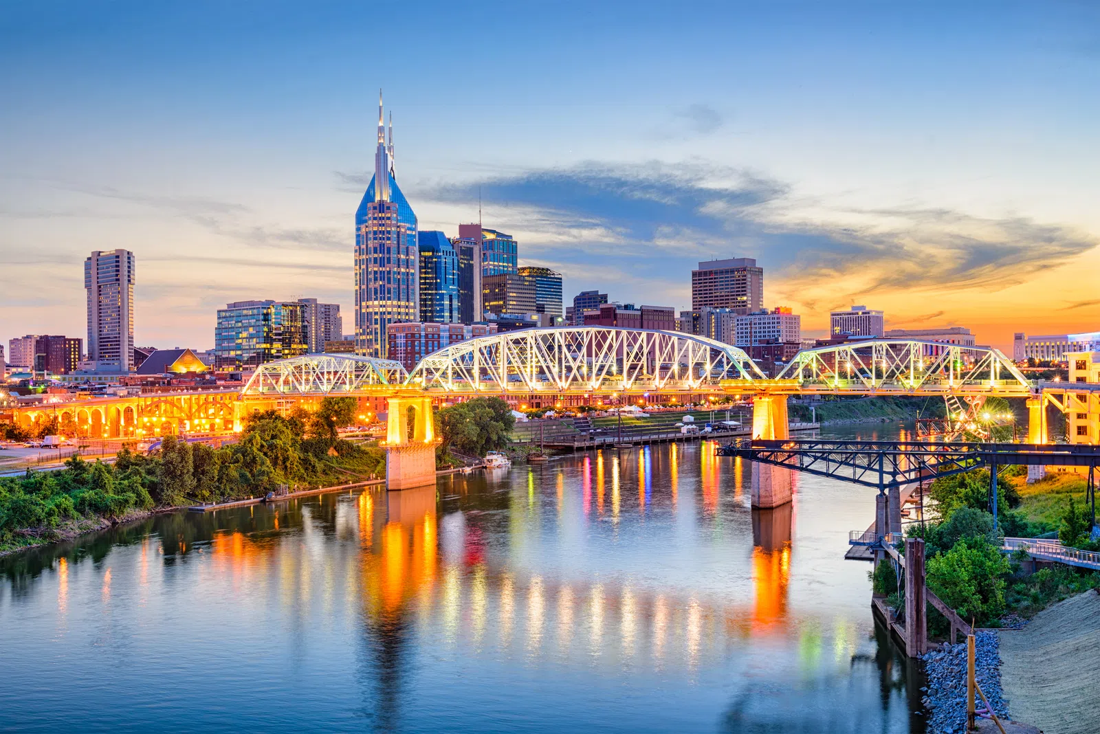 a bridge over a river with a city in the background