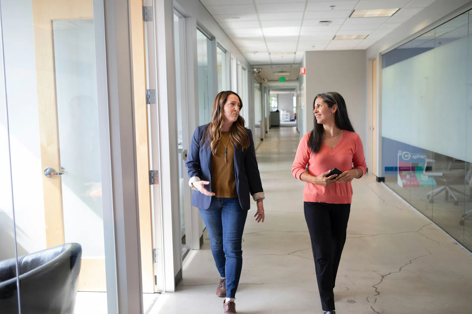 a couple of women walking in a hallway